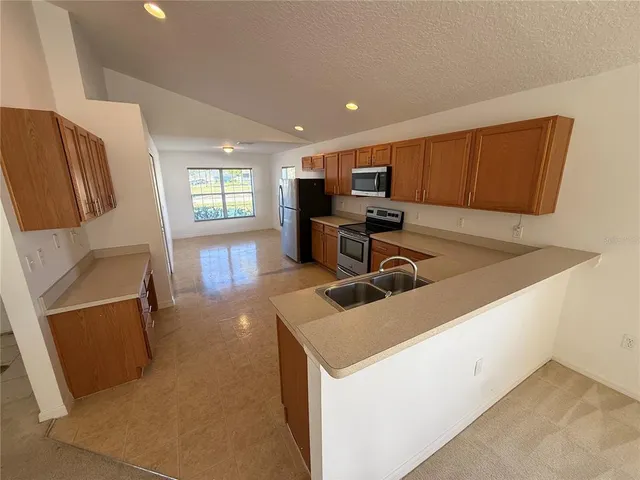 a kitchen with stainless steel appliances granite countertop a sink a stove and a refrigerator
