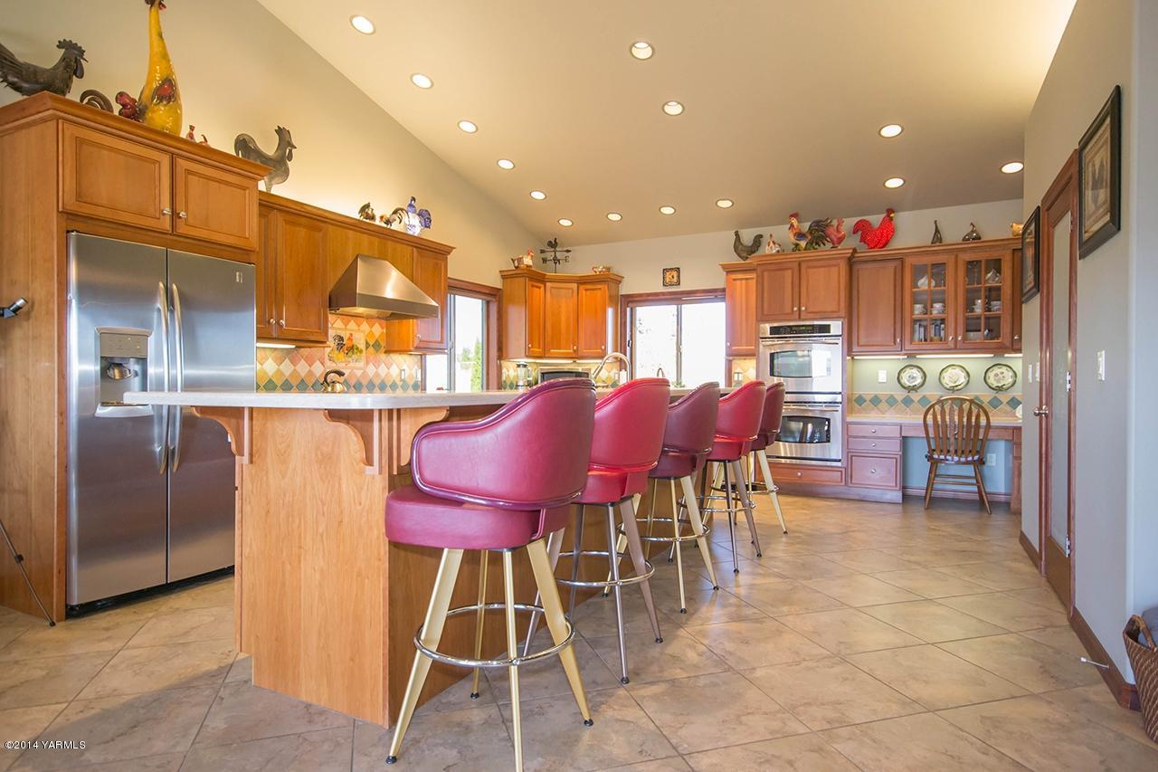 10600 Occidental Road Yakima, WA 98903 - Photo 11 of 40 a kitchen with stainless steel appliances kitchen island granite countertop dining table chairs and a refrigerator