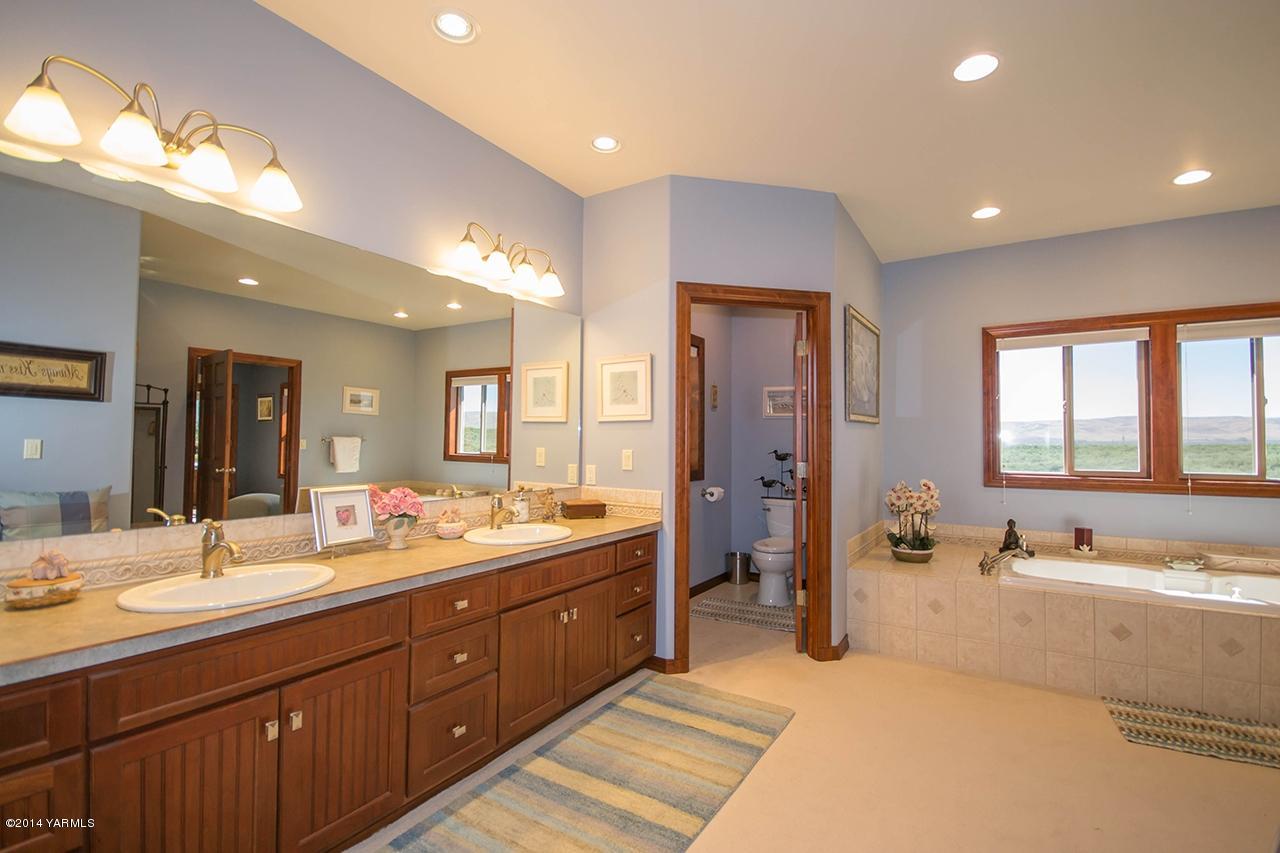 10600 Occidental Road Yakima, WA 98903 - Photo 15 of 40 a spacious bathroom with a double vanity sink large mirror and a bathtub