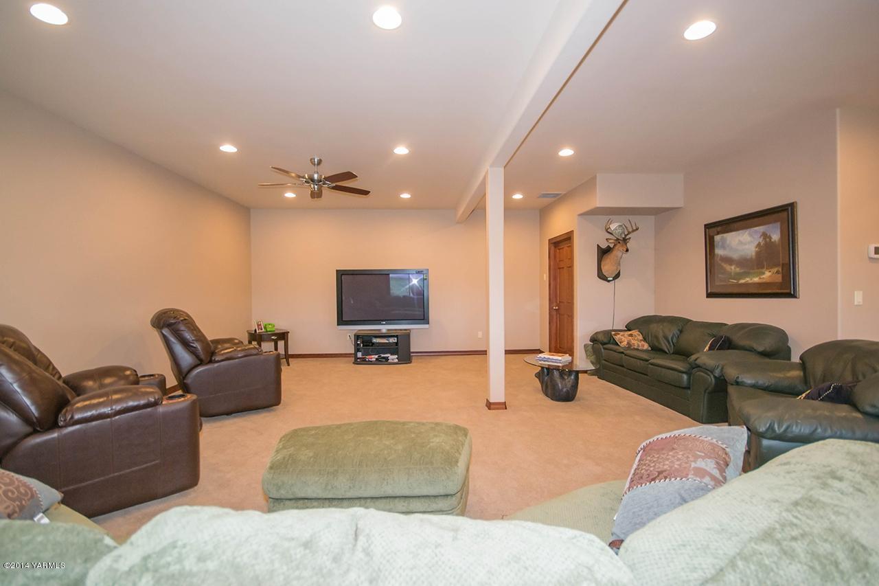 10600 Occidental Road Yakima, WA 98903 - Photo 17 of 40 a living room with furniture gym equipment and a flat screen tv