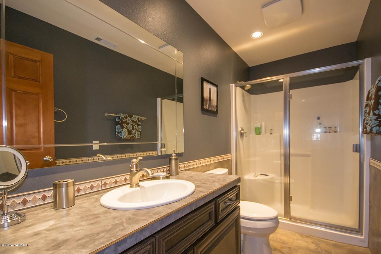 10600 Occidental Road Yakima, WA 98903 - Photo 23 of 40 a bathroom with a granite countertop sink toilet and shower