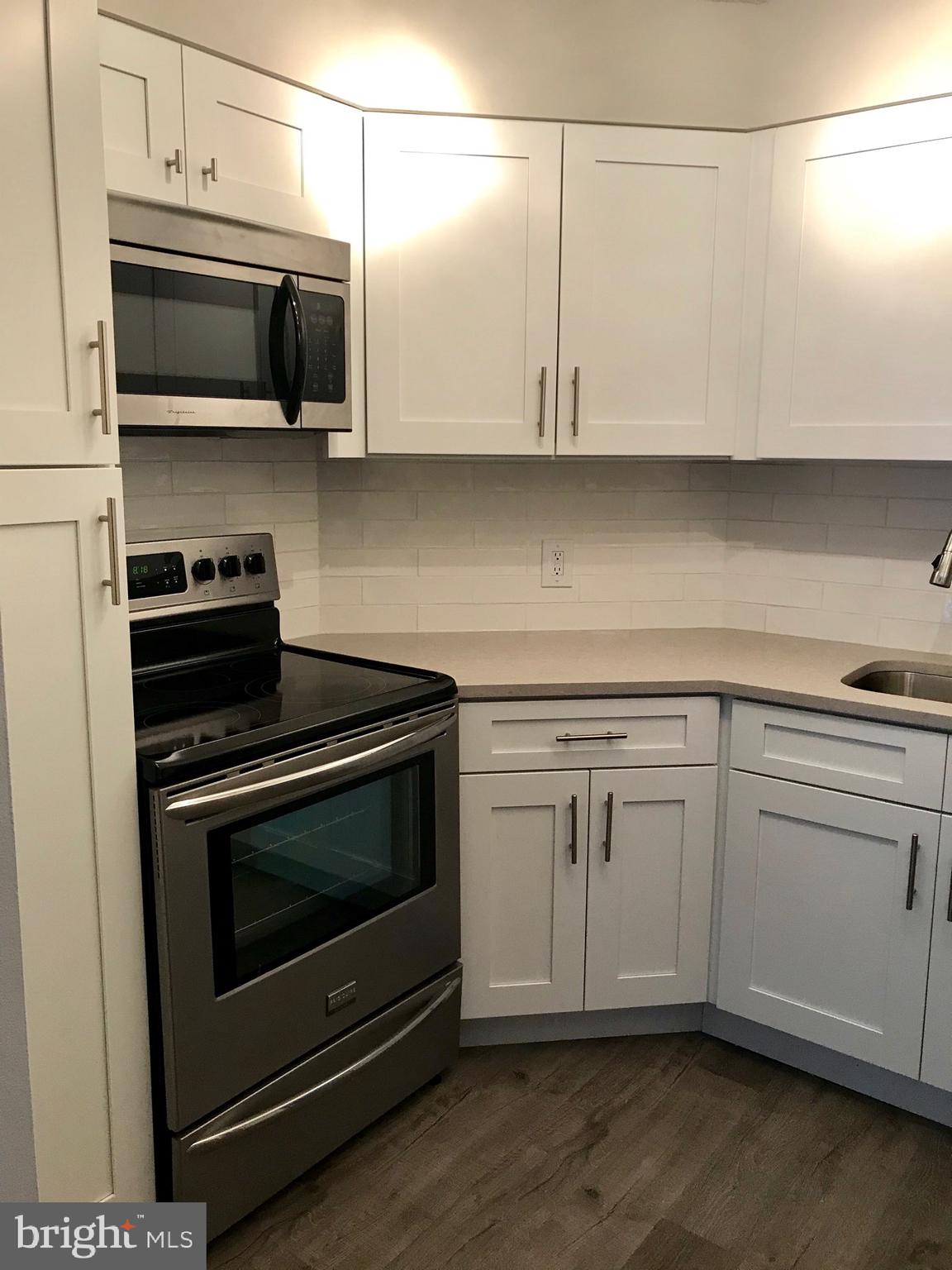 2020 Walnut Street, Unit 10J Philadelphia, PA 19103 - Photo 4 of 18 a kitchen with stainless steel appliances granite countertop a stove microwave and oven