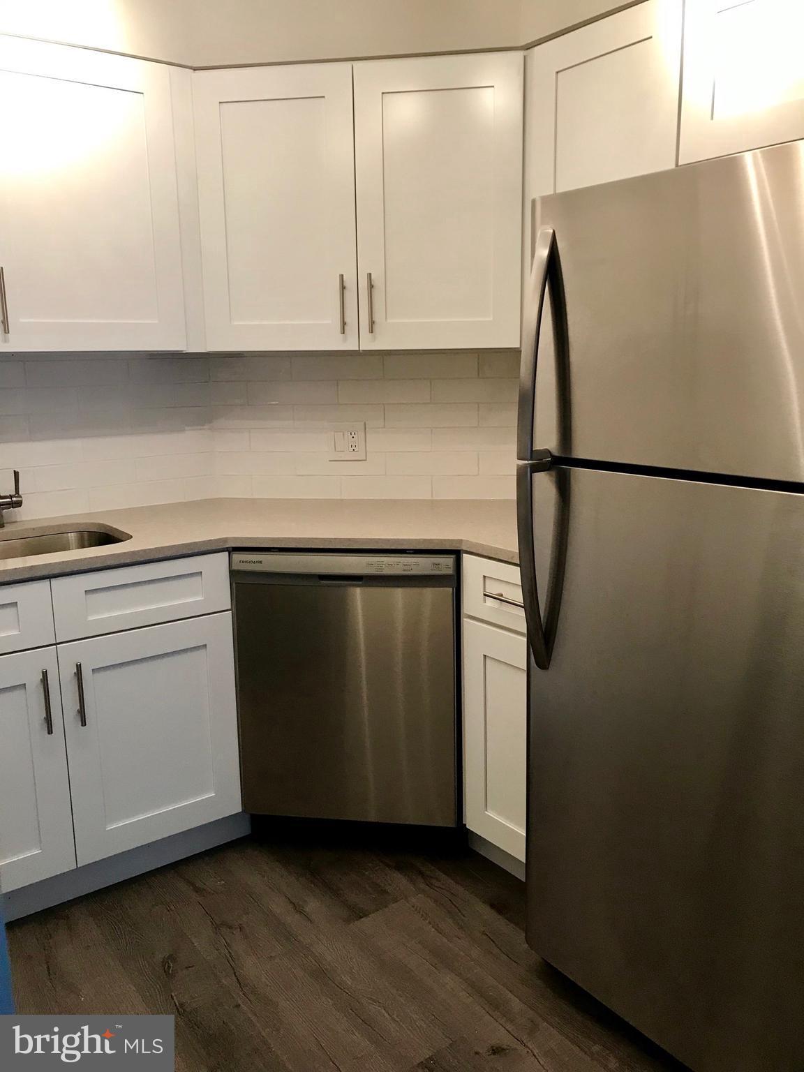 2020 Walnut Street, Unit 10J Philadelphia, PA 19103 - Photo 5 of 18 a kitchen with stainless steel appliances white cabinets and a refrigerator
