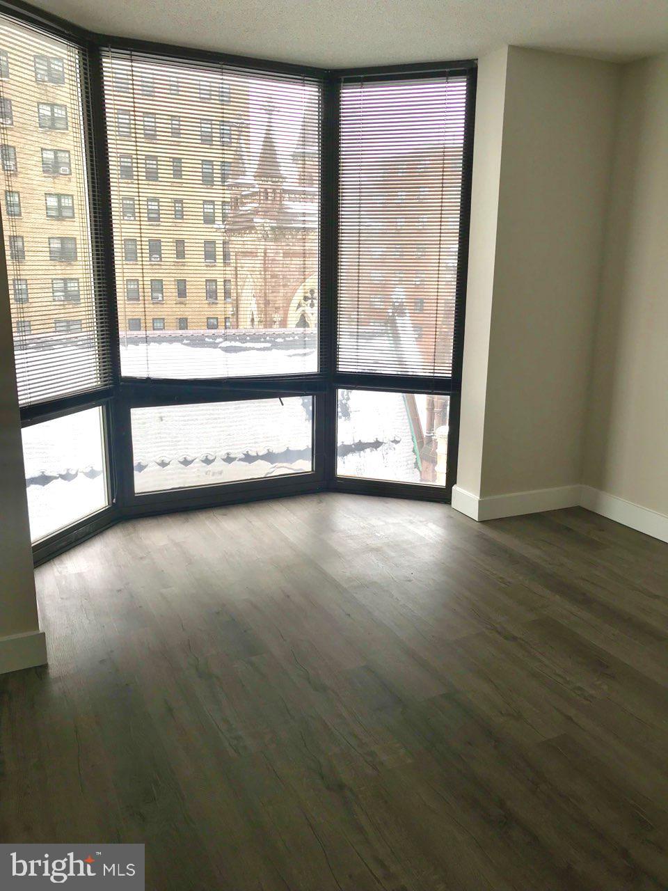 2020 Walnut Street, Unit 10J Philadelphia, PA 19103 - Photo 6 of 18 a view of an empty room with wooden floor and a window
