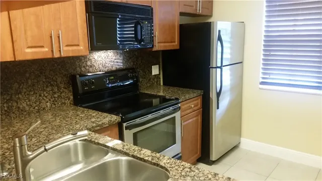 a kitchen with stainless steel appliances granite countertop a refrigerator and a sink