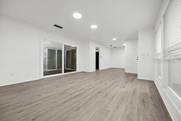 6002 Northwest 33 Street Gainesville, FL 32653 - Photo 12 of 29 a view of an empty room with wooden floor and a window