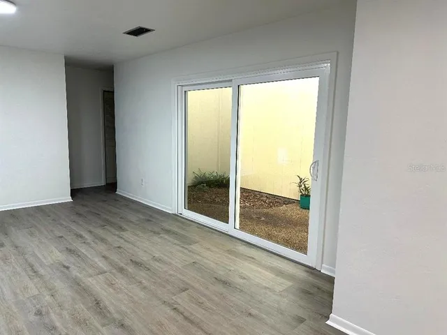 an empty room with wooden floor and door