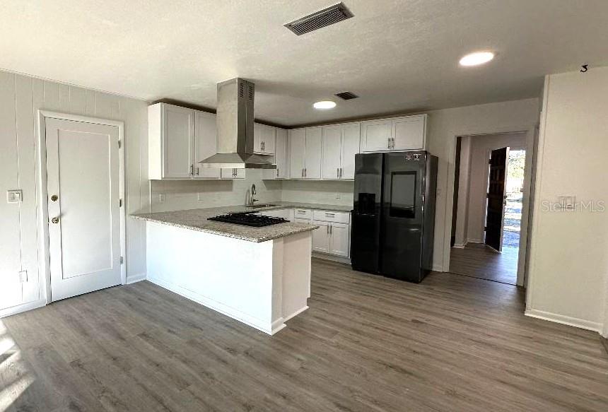 6002 Northwest 33 Street Gainesville, FL 32653 - Photo 9 of 29 a kitchen with a refrigerator and a stove top oven