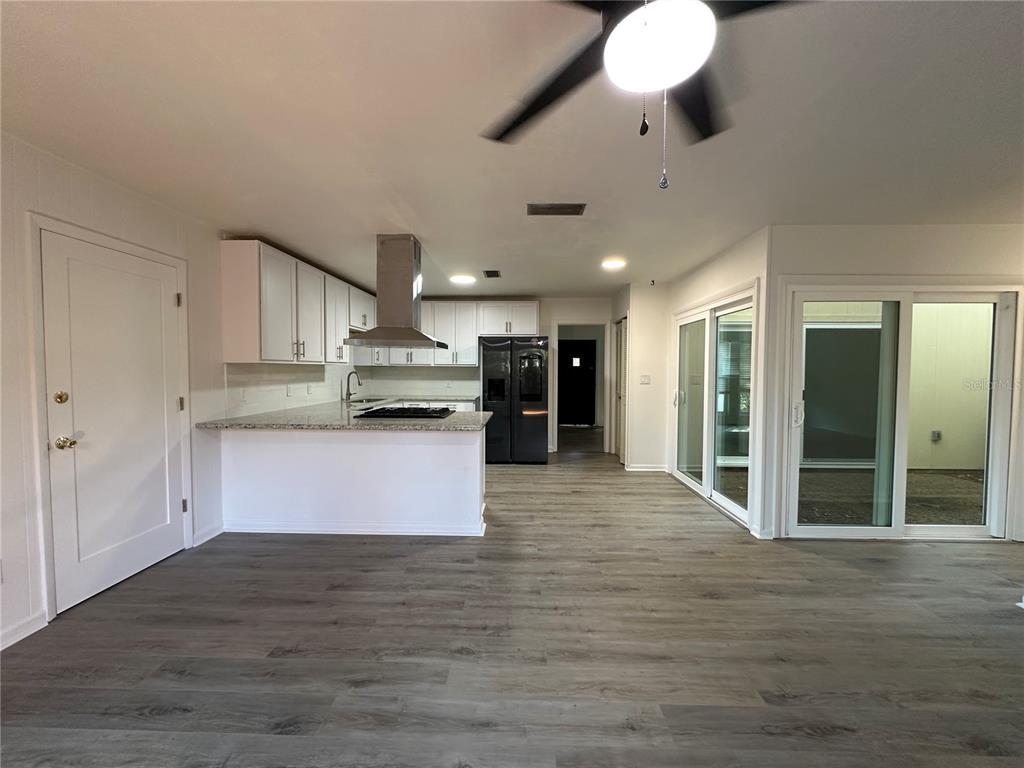 6002 Northwest 33 Street Gainesville, FL 32653 - Photo 10 of 29 a large kitchen with stainless steel appliances kitchen island granite countertop a stove top oven a sink and a granite counter top
