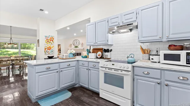 a kitchen with white cabinets and white appliances
