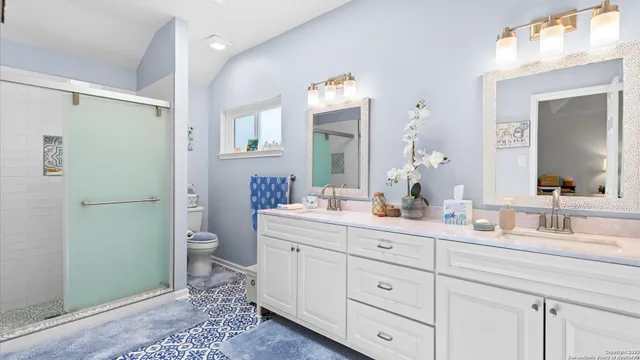 a bath room with a toilet a sink and a mirror
