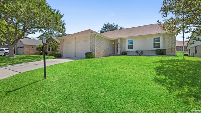a view of a house with a yard and tree s