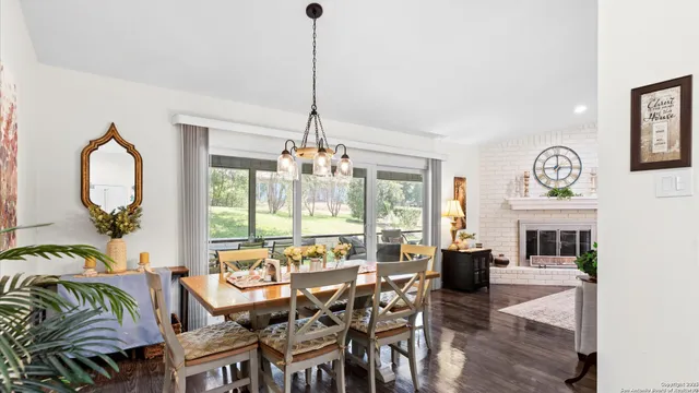 a view of a dining room and livingroom with furniture wooden floor a chandelier