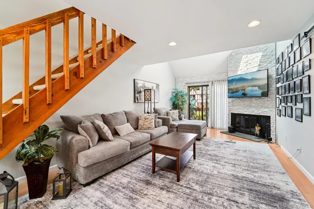 a living room with furniture a fireplace and a floor to ceiling window