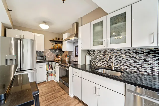 a kitchen with granite countertop a refrigerator and a stove top oven