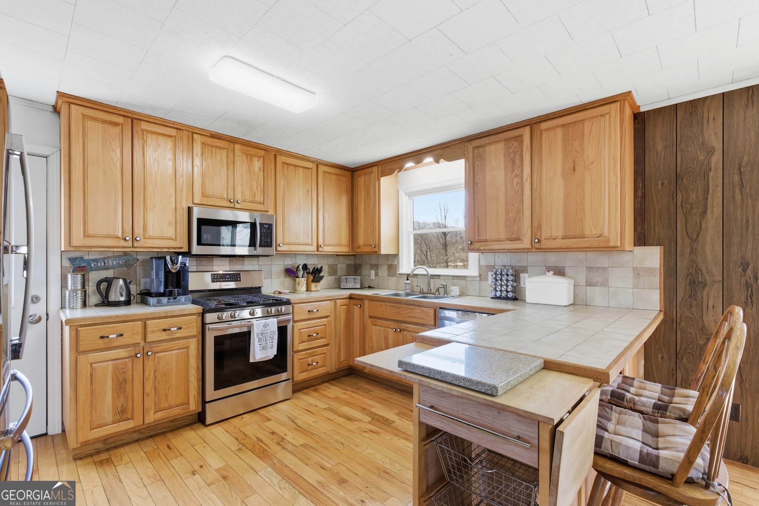 190 Legendary Lane Rabun Gap, GA 30568 - Photo 25 of 47 a kitchen with stainless steel appliances granite countertop a stove a sink dishwasher and a microwave oven with wooden cabinets