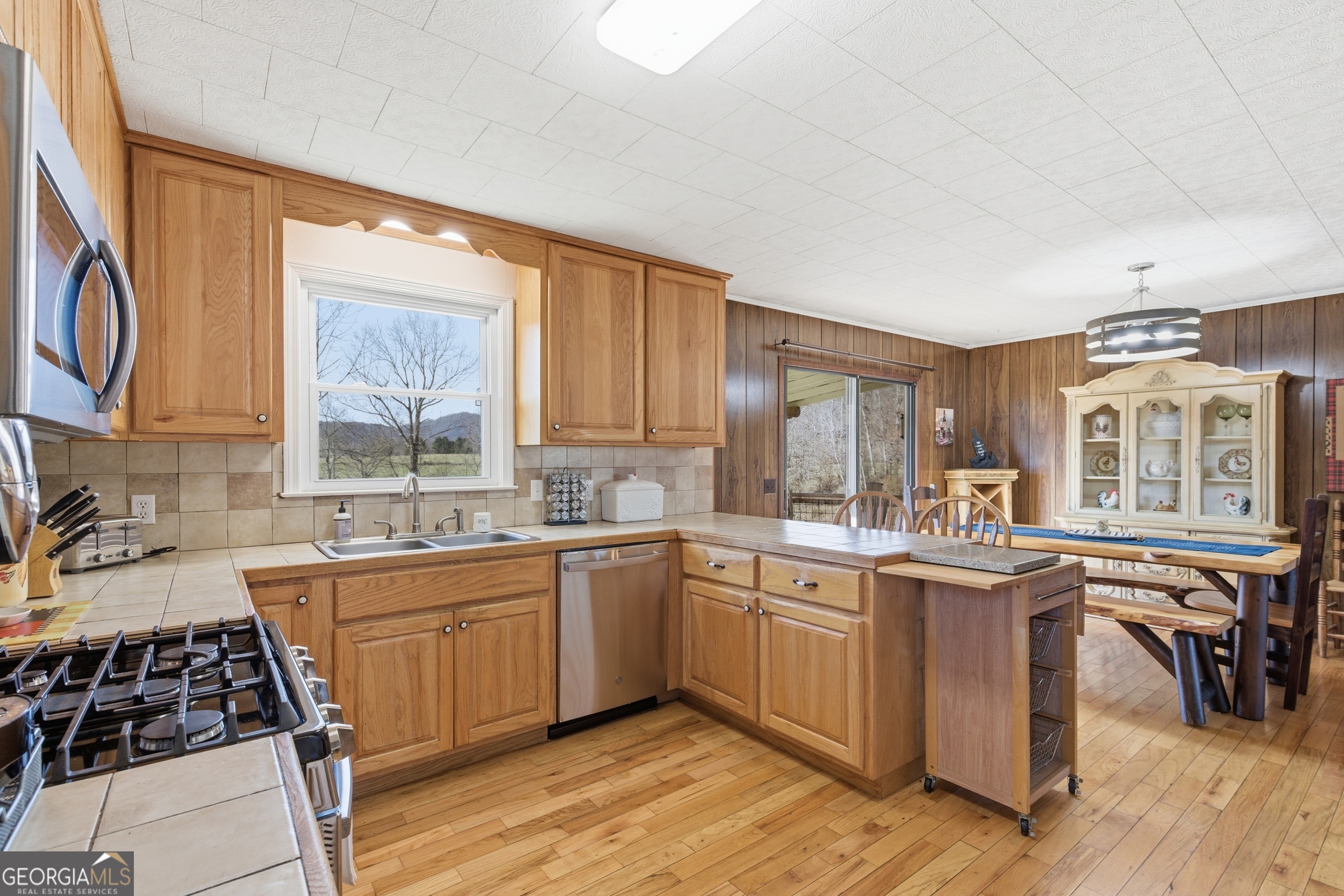 190 Legendary Lane Rabun Gap, GA 30568 - Photo 26 of 47 a kitchen with lots of counter top space sink and wooden floor