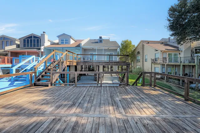 a view of a chairs and table on the wooden roof deck