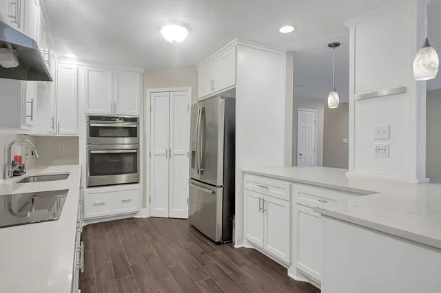 a kitchen with a refrigerator and a stove top oven