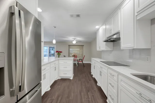 a kitchen with white cabinets and stainless steel appliances