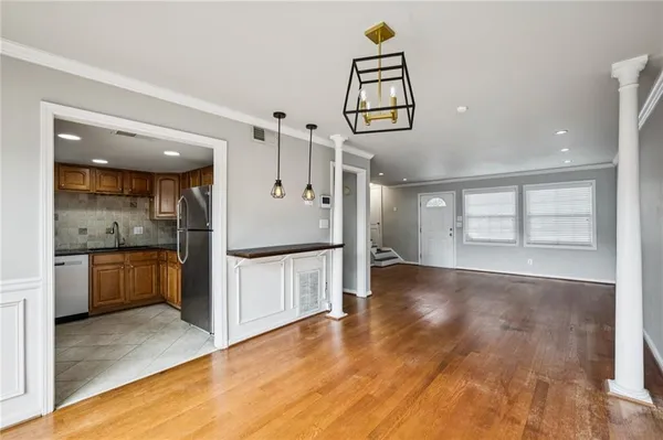 a view of a hallway with wooden floor and a kitchen
