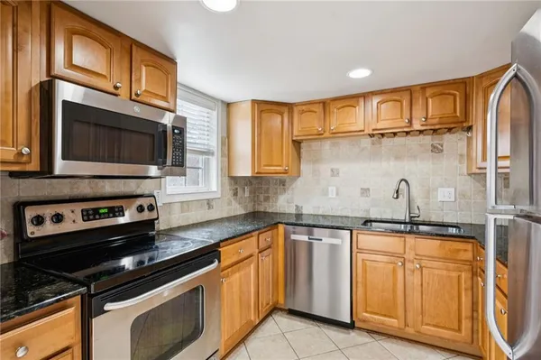 a kitchen with stainless steel appliances a sink stove and cabinets