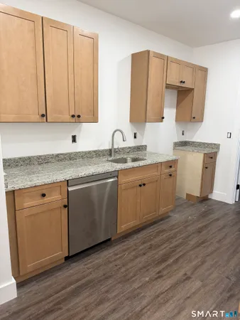 a kitchen with a sink cabinets and wooden floor