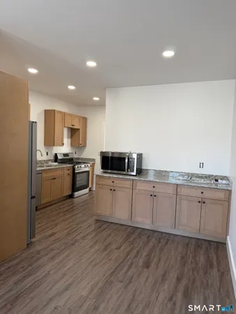 a kitchen with granite countertop white cabinets and white appliances