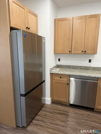 a kitchen with stainless steel appliances granite countertop a refrigerator and a sink