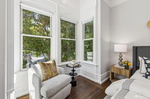 a view of a brick house with large windows and a large tree