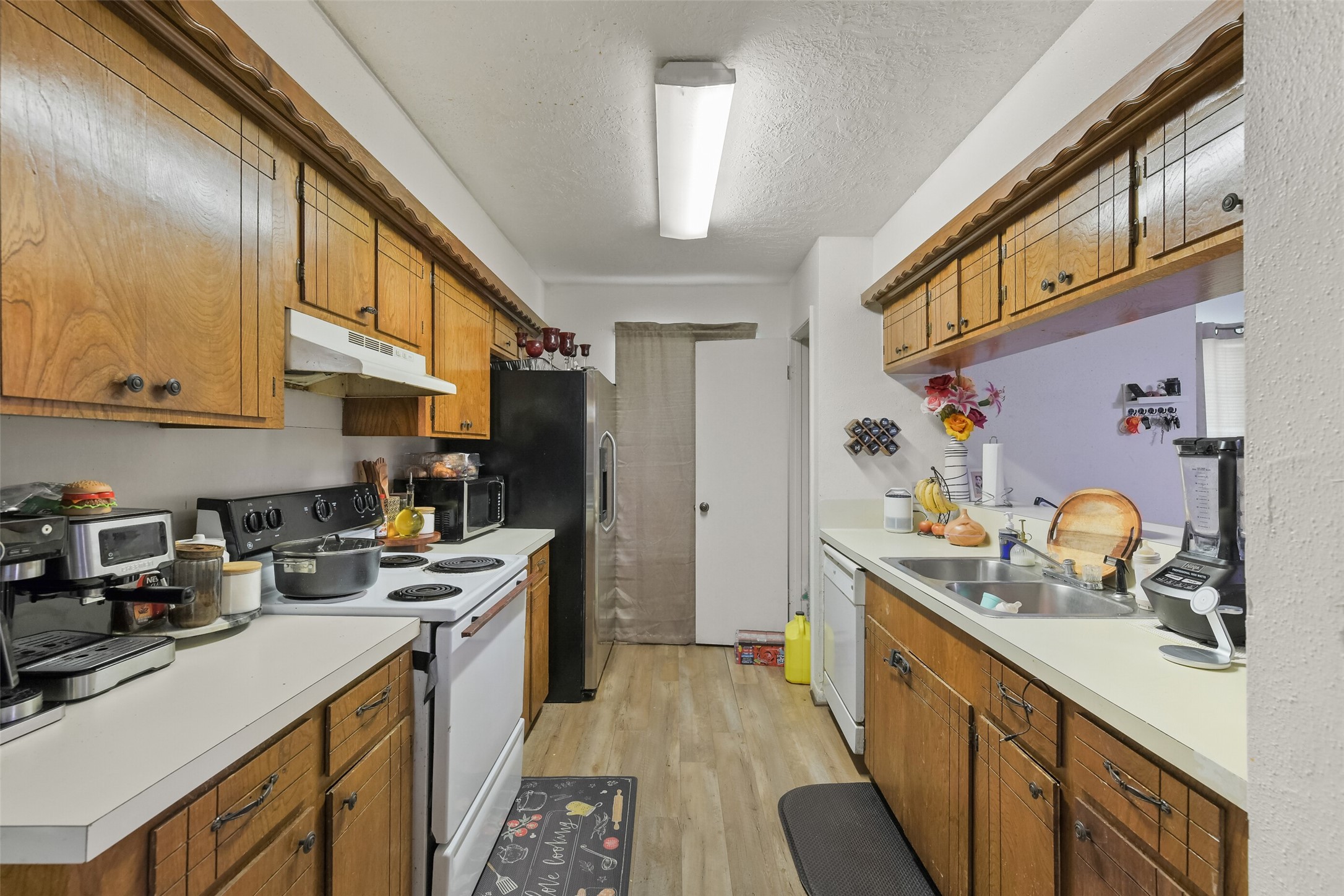 217 Lazy Lane, Unit B Conroe, TX 77301 - Photo 15 of 27 a kitchen with stainless steel appliances a sink stove top oven and cabinets
