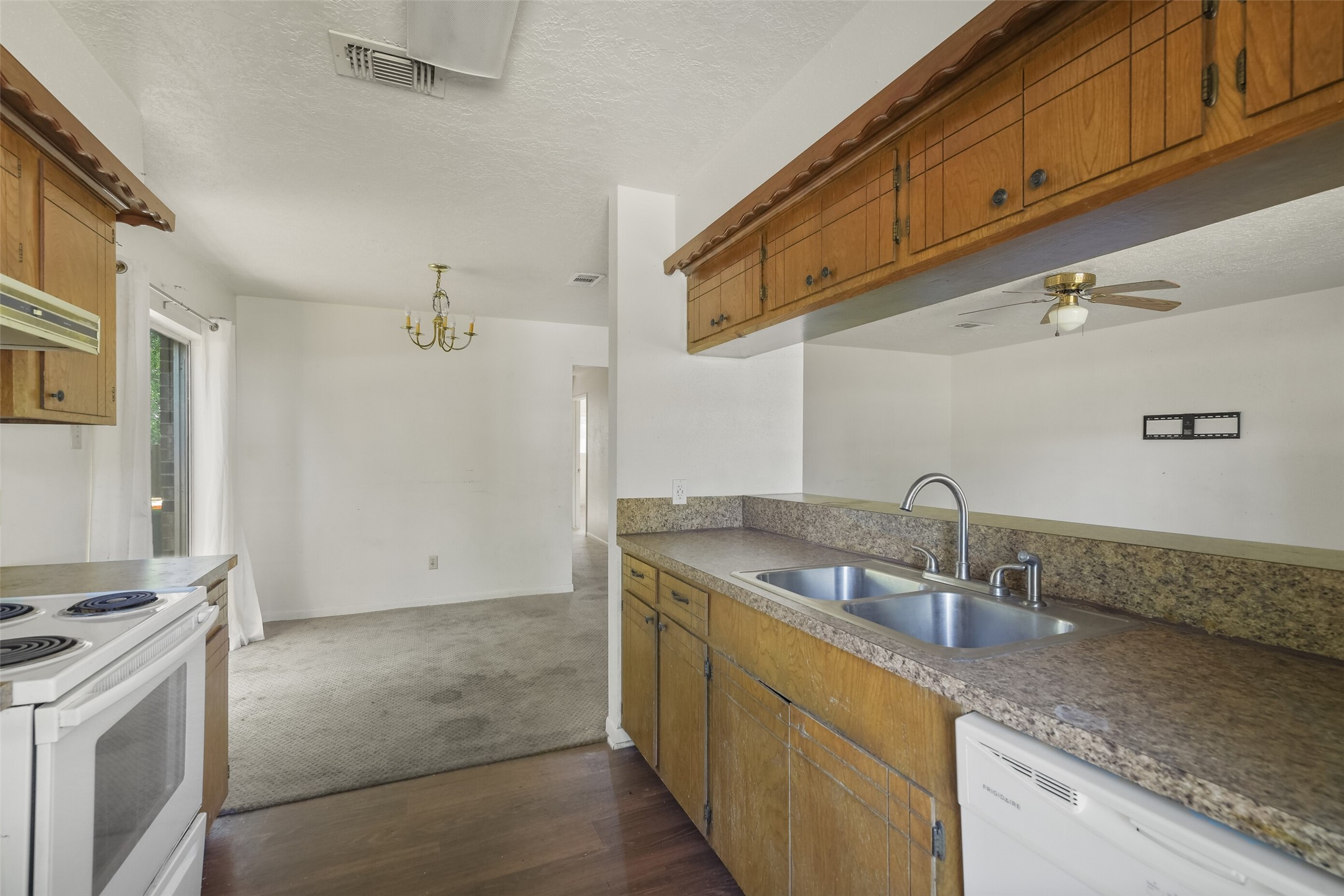 217 Lazy Lane, Unit B Conroe, TX 77301 - Photo 5 of 27 a kitchen with granite countertop a sink a stove and cabinets