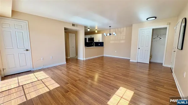 a view of a hallway with wooden floor and windows