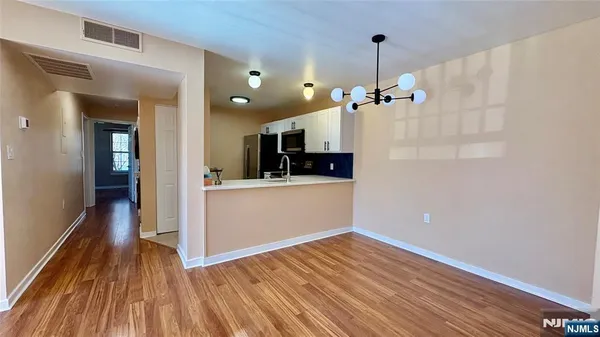 a view of a kitchen from the hallway with a sink