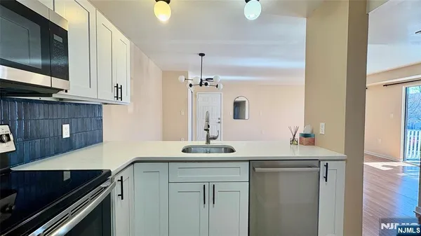a kitchen with a sink and a stove top oven with wooden floor
