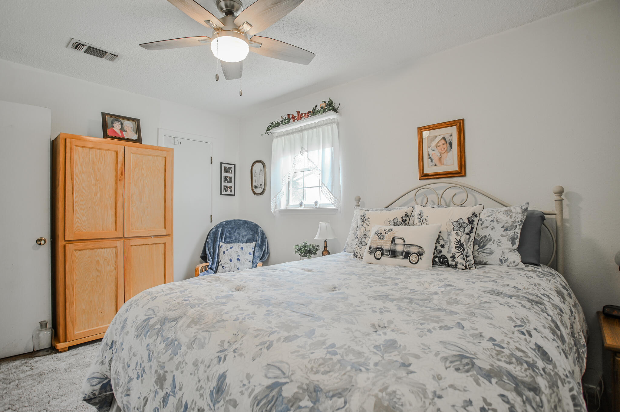720 South 23rd Street Slaton, TX 79364 - Photo 22 of 46 a bedroom with a large bed and a chandelier