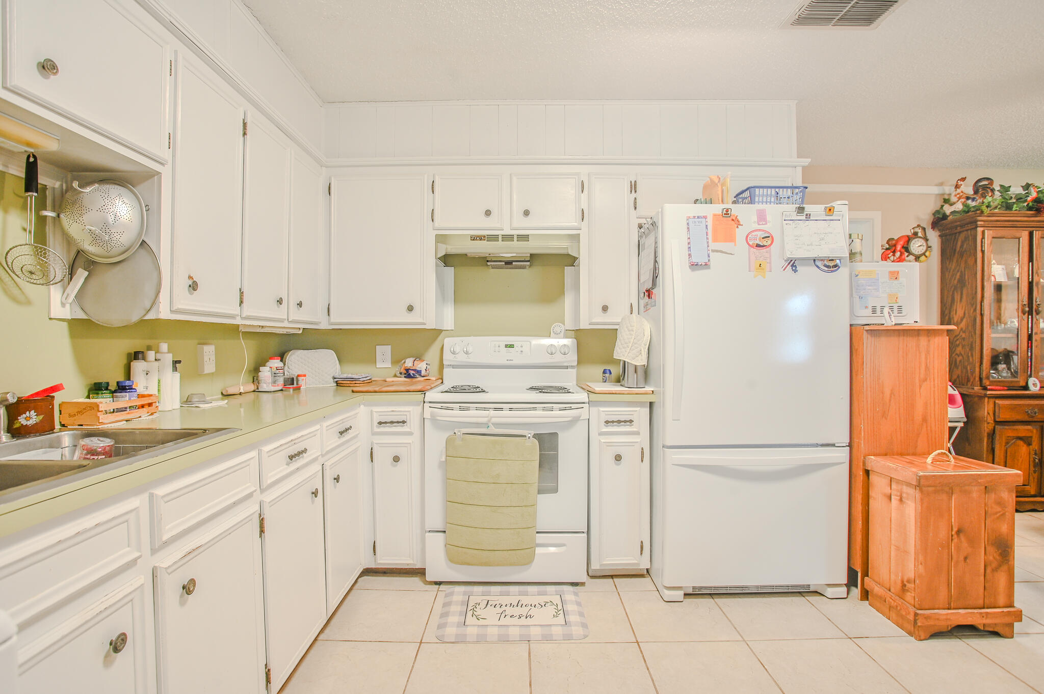 720 South 23rd Street Slaton, TX 79364 - Photo 31 of 46 a kitchen with a refrigerator a stove and cabinets