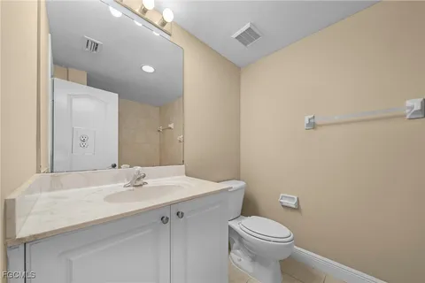 a view of bathroom with a toilet a sink and a mirror