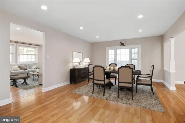 a view of dining room and livingroom with furniture wooden floor a rug a fireplace and a window