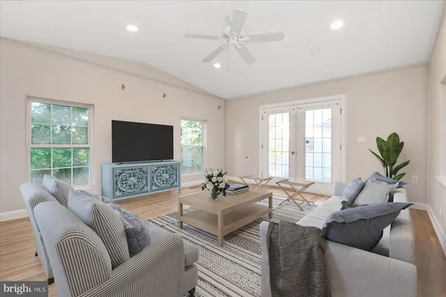 a living room with furniture a flat screen tv and a large window