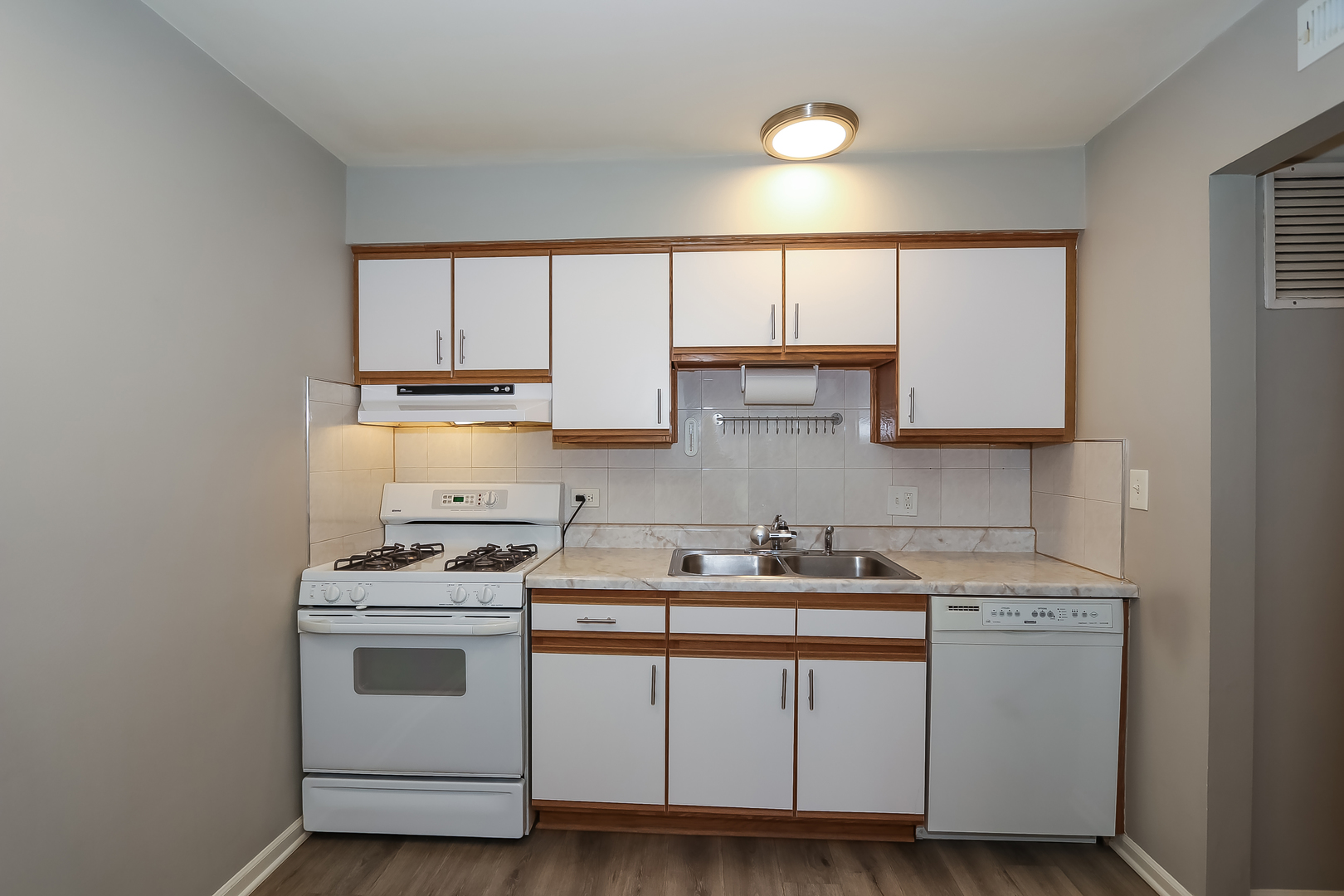 5000 Carriageway Drive, Unit 103 Rolling Meadows, IL 60008 - Photo 6 of 22 a kitchen with cabinets appliances a sink and a window
