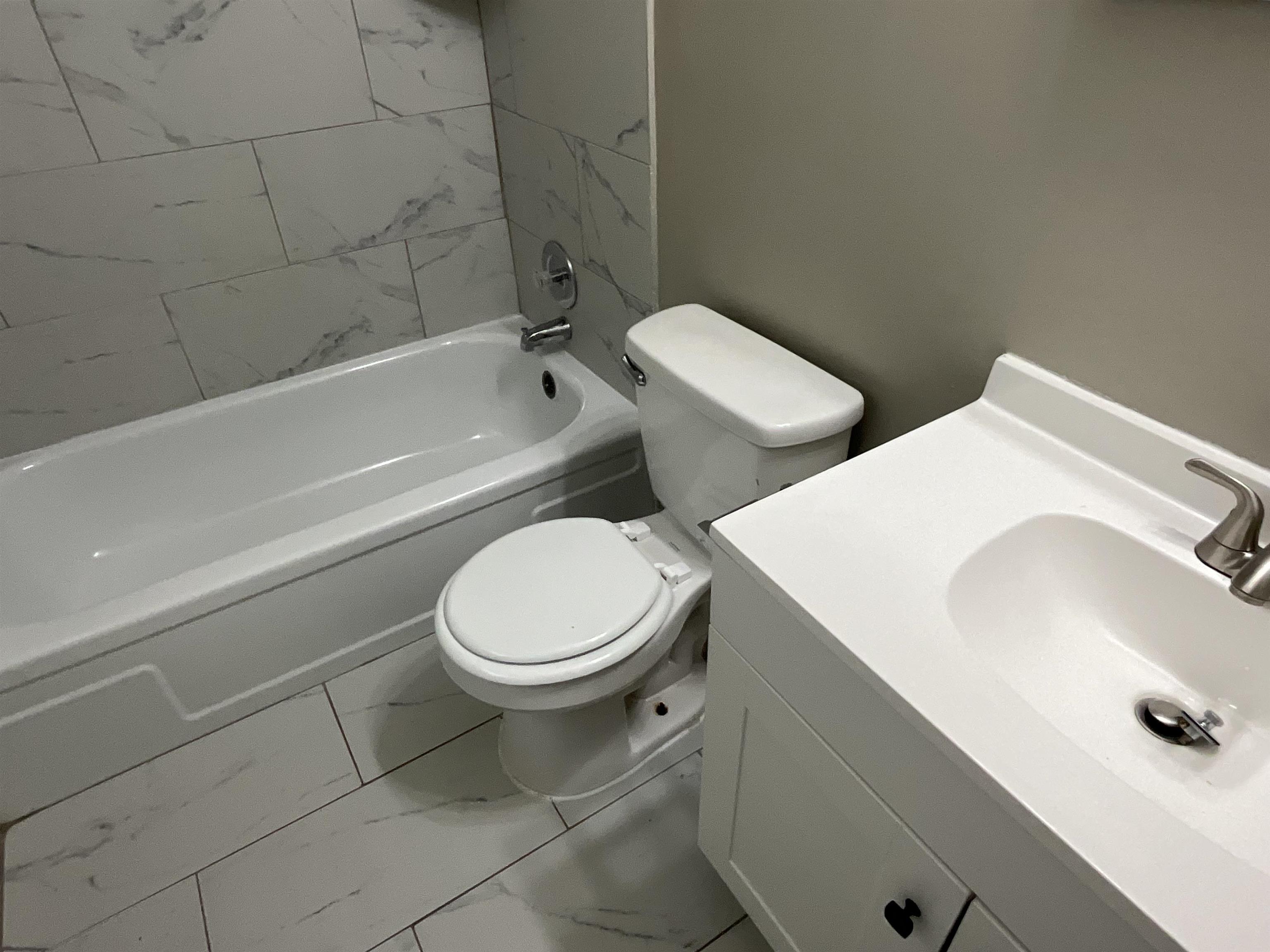 4455 Macon Road, Unit 4 Memphis, TN 38122 - Photo 9 of 11 a white toilet sitting next to a bath tub