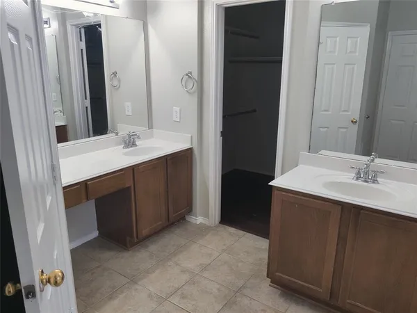 a bathroom with a double vanity sink and mirror