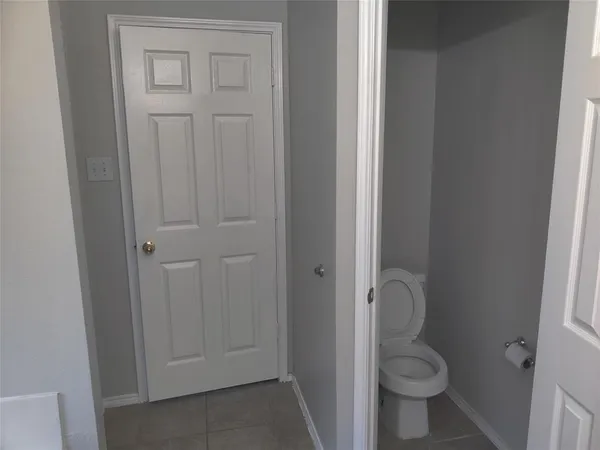 a bathroom with a granite countertop toilet and a sink