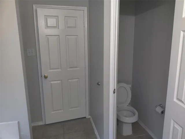 a bathroom with a granite countertop toilet and a sink