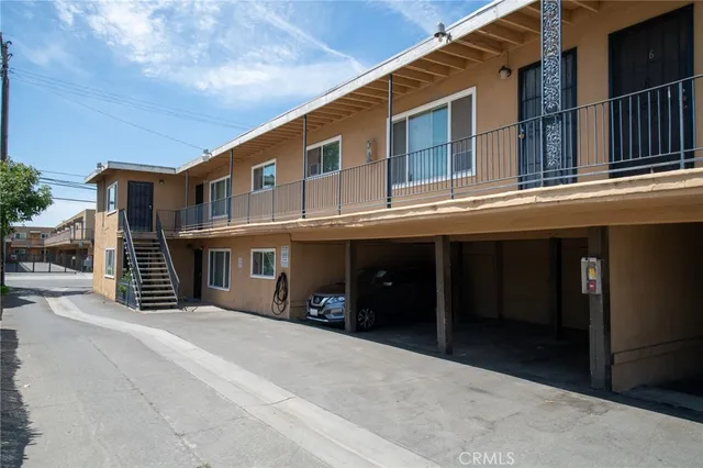 a view of a house with a barbeque and wooden stairs
