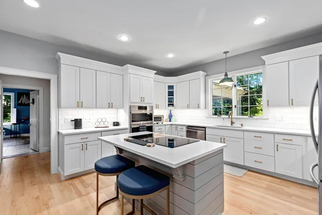 a kitchen with a stove a sink a window and dining table