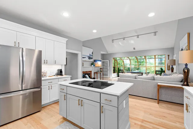 a kitchen that has a refrigerator a sink stainless steel appliances and cabinets
