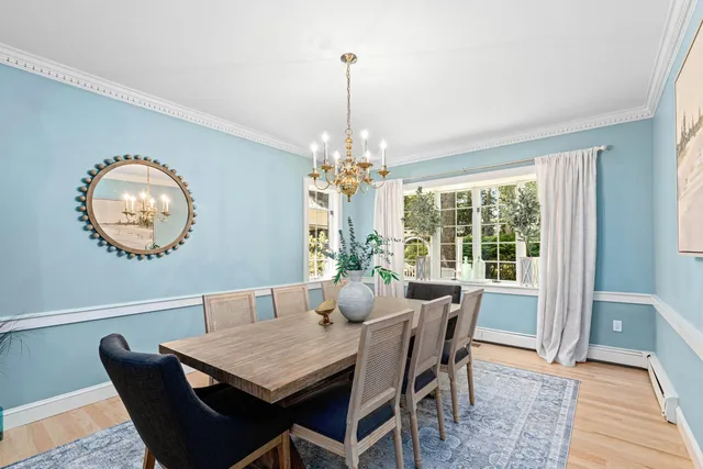 a view of a dining room with furniture a chandelier and wooden floor