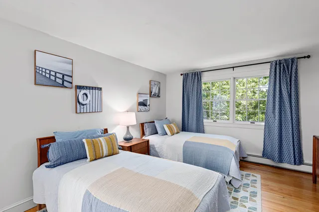 a bedroom with two beds and a large window